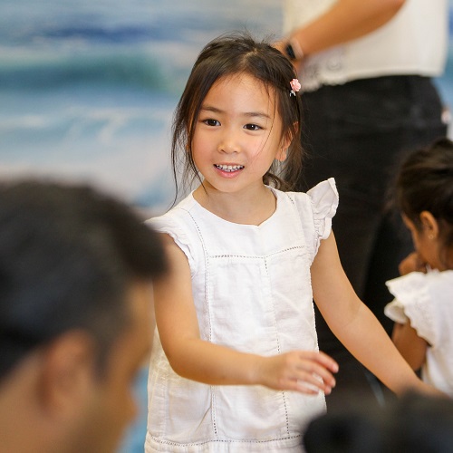 Young girl participating in a classroom performance activity at preschool